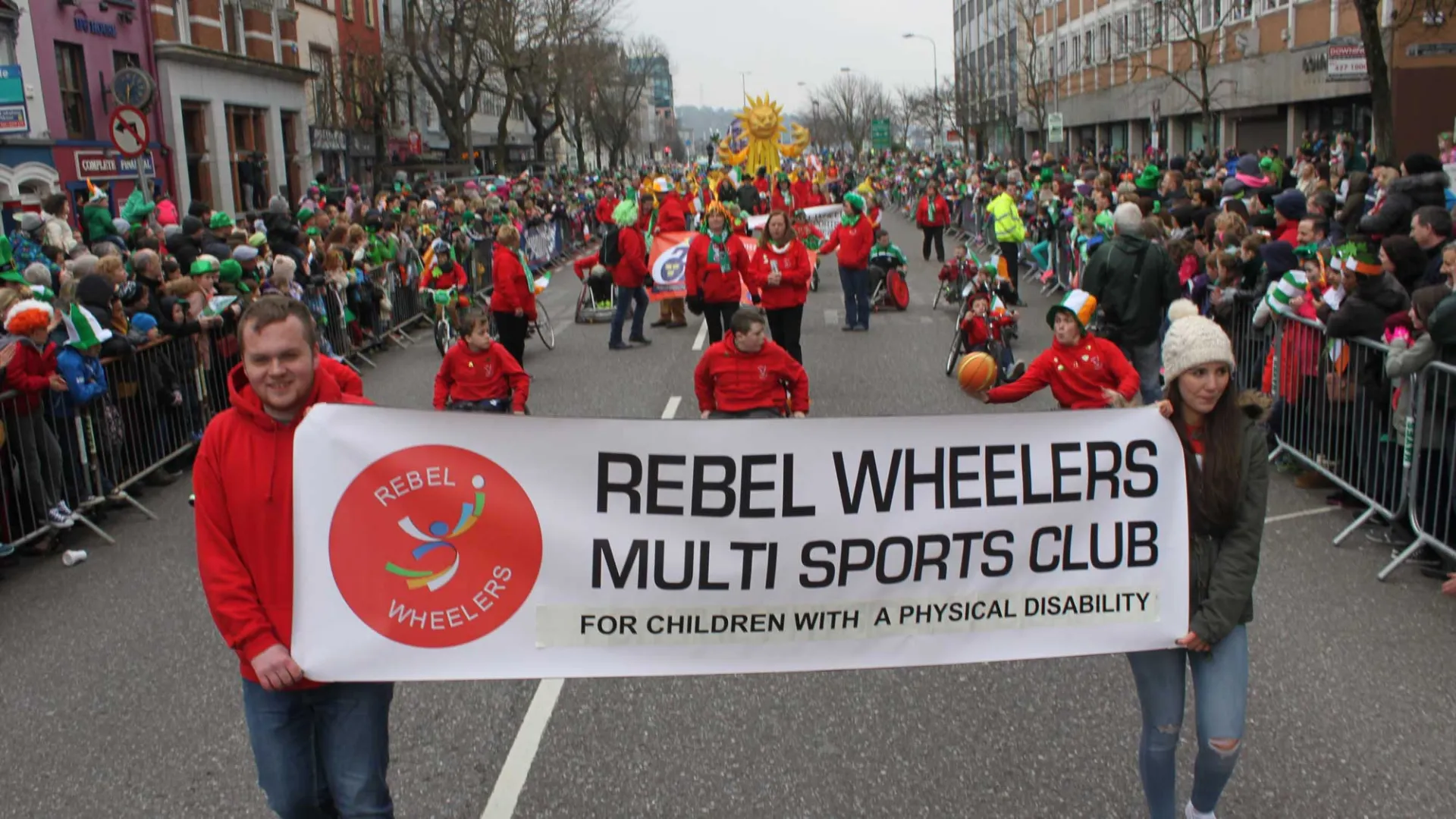 Rebel Wheelers on parade with banner